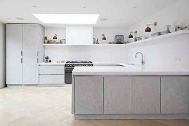 Inspiration for a mid-sized contemporary u-shaped eat-in kitchen in London with a double-bowl sink, flat-panel cabinets, grey cabinets, quartzite benchtops, white splashback, light hardwood floors and yellow floor.