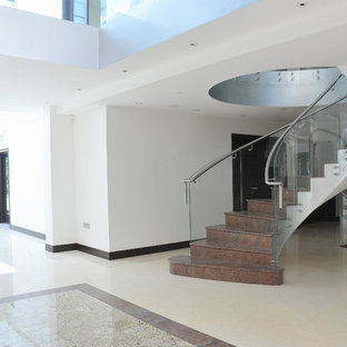 Inspiration for a contemporary glass railing staircase in London with marble treads and marble risers.