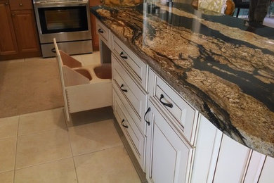 Photo of a large traditional separate kitchen in Miami with raised-panel cabinets, white cabinets, marble benchtops, ceramic floors, with island and beige floor.
