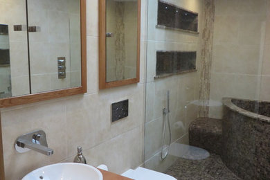 This is an example of a small contemporary ensuite bathroom in Other with a corner bath, a built-in shower, a wall mounted toilet, beige tiles, mosaic tiles, beige walls, mosaic tile flooring and a vessel sink.