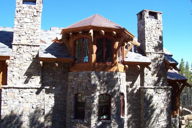 Huge rustic brown two-story brick exterior home idea in Other