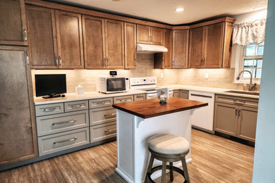 Inspiration for a mid-sized transitional l-shaped vinyl floor and multicolored floor eat-in kitchen remodel in Other with an undermount sink, shaker cabinets, solid surface countertops, beige backsplash, subway tile backsplash, white appliances, an island and white countertops
