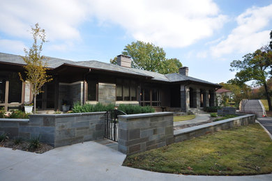 This is an example of a large modern grey exterior in Little Rock with stone veneer.
