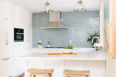 Inspiration for a small transitional u-shaped medium tone wood floor and red floor eat-in kitchen remodel in Seattle with an undermount sink, shaker cabinets, white cabinets, quartz countertops, blue backsplash, ceramic backsplash, stainless steel appliances, a peninsula and white countertops