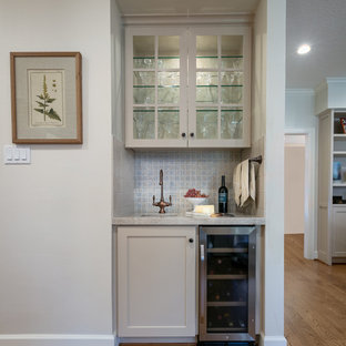 ヒューストンの小さいトランジショナルスタイルのおしゃれなウェットバー (アンダーカウンターシンク、シェーカースタイル扉のキャビネット、ベージュのキャビネット、珪岩カウンター、青いキッチンパネル、セメントタイルのキッチンパネル、淡色無垢フローリング、茶色い床、ベージュのキッチンカウンター) の写真