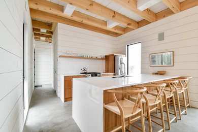 Example of a mountain style concrete floor and gray floor kitchen design in Toronto with medium tone wood cabinets, white backsplash, stainless steel appliances, a peninsula and white countertops