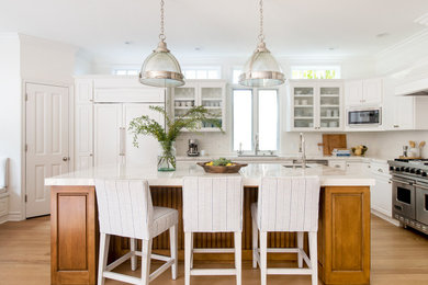 Example of a transitional kitchen design in Los Angeles with beaded inset cabinets, white backsplash, porcelain backsplash, paneled appliances, an island and white countertops