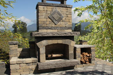 Large country backyard patio in Vancouver with a fire feature, concrete pavers and no cover.