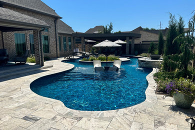 Pool - large contemporary backyard stone and custom-shaped pool idea in Oklahoma City