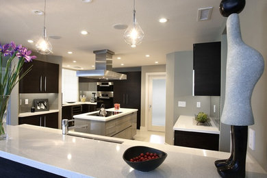 Inspiration for a large modern u-shaped ceramic tile enclosed kitchen remodel in San Francisco with a double-bowl sink, flat-panel cabinets, black cabinets, stainless steel appliances and an island