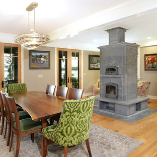 Design ideas for an arts and crafts open plan dining in Grand Rapids with grey walls, light hardwood floors, a standard fireplace, a tile fireplace surround and brown floor.