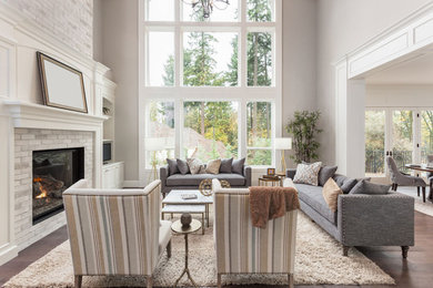 Large elegant formal and open concept dark wood floor and brown floor living room photo in Calgary with gray walls, a standard fireplace and a brick fireplace