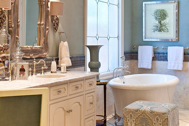 Inspiration for a mid-sized traditional master bathroom in Dallas with raised-panel cabinets, white cabinets, granite benchtops, blue walls, ceramic floors, a claw-foot tub, beige tile and ceramic tile.