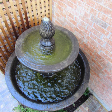 High function in a small side yard! Pergola, raised bed, mirrored wall, fountain