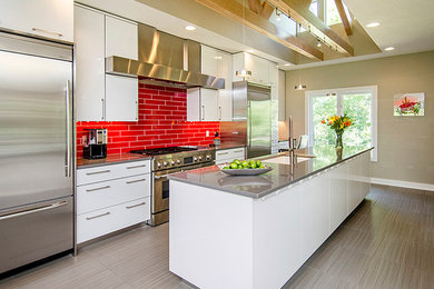 Inspiration for a mid-sized contemporary l-shaped light wood floor eat-in kitchen remodel in Other with a single-bowl sink, flat-panel cabinets, white cabinets, solid surface countertops, red backsplash, subway tile backsplash, stainless steel appliances and an island