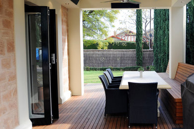 This is an example of a mid-sized contemporary side yard patio in Adelaide with an outdoor kitchen, decking and a roof extension.