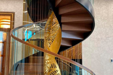 Стильный дизайн: большая винтовая деревянная лестница в стиле фьюжн с деревянными ступенями и перилами из смешанных материалов - последний тренд