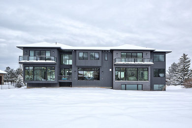 Inspiration for a large modern gray two-story mixed siding house exterior remodel in Toronto with a hip roof and a shingle roof