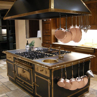 Réalisation d'une grande arrière-cuisine méditerranéenne en U avec un évier intégré, un placard à porte shaker, des portes de placard en bois sombre, un plan de travail en stéatite, une crédence multicolore, une crédence en carrelage de pierre, un électroménager de couleur, un sol en calcaire et un îlot central.