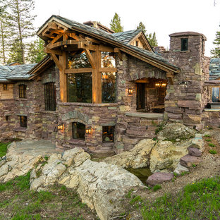 Example of a stone exterior home design in Other with a tile roof
