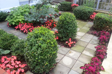 This is an example of a contemporary shade front yard stone formal garden in Chicago for summer.