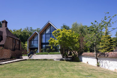 Inspiration for a large modern two floor detached house in Hampshire with wood cladding.