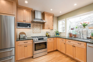 Inspiration for a mid-sized timeless light wood floor and beige floor kitchen remodel in San Francisco with an undermount sink, beaded inset cabinets, light wood cabinets, stainless steel appliances, no island and black countertops