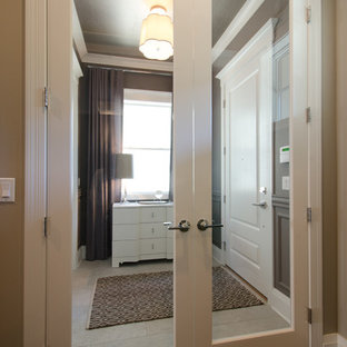 Inredning av en eklektisk foajé, med grå väggar, kalkstensgolv, en enkeldörr och en vit dörr