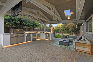 Inspiration for a large transitional backyard concrete paver patio kitchen remodel in San Francisco with a roof extension