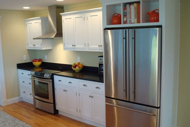 Kitchen pantry - traditional single-wall medium tone wood floor kitchen pantry idea in Other with raised-panel cabinets, white cabinets, granite countertops and an island