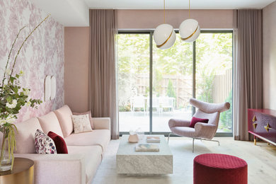 This is an example of a large contemporary open concept living room in New York with pink walls, a wall-mounted tv, light hardwood floors, no fireplace and beige floor.