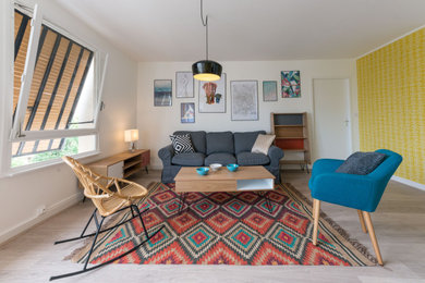 Foto de sala de estar abierta nórdica grande sin televisor con paredes amarillas, suelo de madera clara y papel pintado