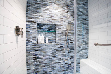 Walk-in shower - mid-sized contemporary master blue tile and glass sheet ceramic tile walk-in shower idea in San Francisco with furniture-like cabinets, white cabinets, a one-piece toilet, white walls, a drop-in sink and solid surface countertops