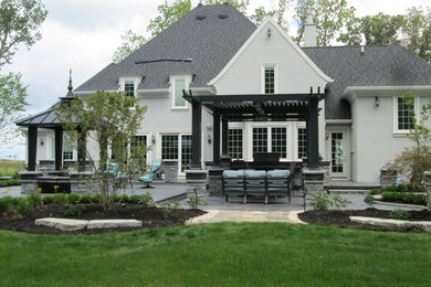 Inspiration for a large modern backyard stone patio kitchen remodel in Other with a pergola
