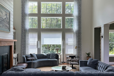 Imagen de salón abierto moderno grande sin televisor con paredes blancas, marco de chimenea de madera, suelo marrón y vigas vistas