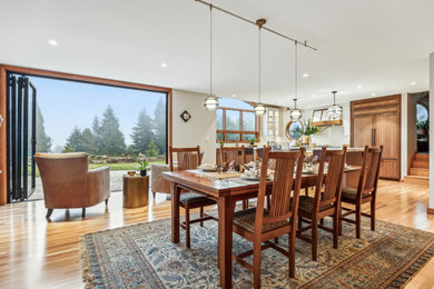 Eat-in kitchen - large l-shaped light wood floor and brown floor eat-in kitchen idea in Portland with a farmhouse sink, shaker cabinets, medium tone wood cabinets, tile countertops, white backsplash, porcelain backsplash, paneled appliances, an island and white countertops