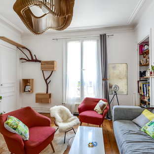 Réalisation d'un salon bohème avec un mur blanc et un sol en bois brun.