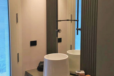 Immagine di un bagno di servizio contemporaneo con piastrelle in ceramica, lavabo a bacinella e top in cemento