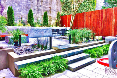 This is an example of a modern backyard stone and wood fence formal garden in San Francisco with a fire pit.