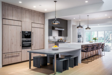 Inspiration for a contemporary light wood floor and beige floor eat-in kitchen remodel in Los Angeles with flat-panel cabinets, an island, an undermount sink, white backsplash, white countertops, medium tone wood cabinets and paneled appliances