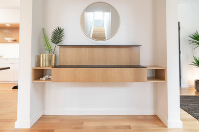 Inspiration for a mid-sized modern medium tone wood floor and brown floor hallway remodel in Seattle with white walls