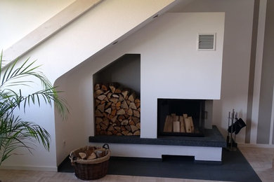 Großes, Repräsentatives, Fernseherloses, Offenes Klassisches Wohnzimmer mit Kaminofen, Kaminumrandung aus Beton, weißer Wandfarbe, hellem Holzboden und beigem Boden in Nürnberg