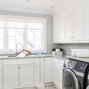 トロントの大きいトラディショナルスタイルのおしゃれな洗濯室 (左右配置の洗濯機・乾燥機、落し込みパネル扉のキャビネット、白いキャビネット、アンダーカウンターシンク、御影石カウンター、大理石の床、グレーの壁) の写真