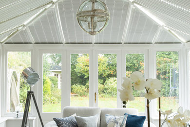 Traditional conservatory in Other with light hardwood flooring and feature lighting.