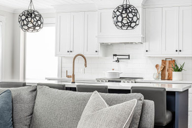 Inspiration for a mid-sized cottage l-shaped medium tone wood floor and shiplap ceiling open concept kitchen remodel in Toronto with an undermount sink, shaker cabinets, white cabinets, quartz countertops, white backsplash, subway tile backsplash, stainless steel appliances, an island and white countertops