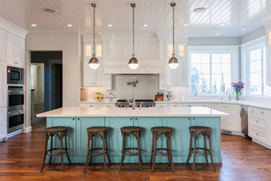 Mid-sized farmhouse u-shaped medium tone wood floor and brown floor open concept kitchen photo in Minneapolis with an undermount sink, shaker cabinets, turquoise cabinets, white backsplash, stone slab backsplash, stainless steel appliances and an island