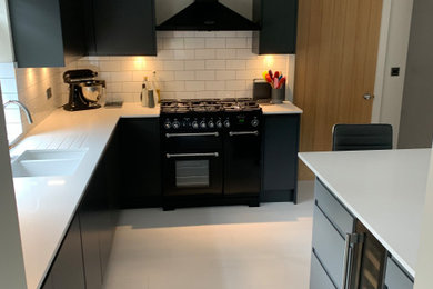 Design ideas for a medium sized modern l-shaped kitchen/diner in Other with flat-panel cabinets, grey cabinets, quartz worktops, an island and white worktops.