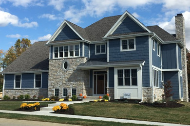 Example of a mid-sized transitional blue two-story concrete fiberboard house exterior design in Chicago with a hip roof and a shingle roof