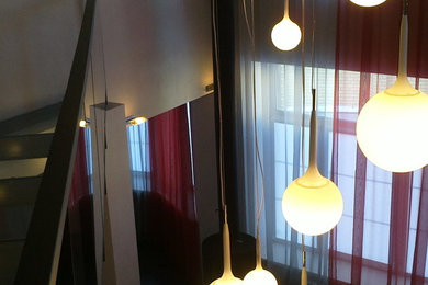 Источник вдохновения для домашнего уюта: огромная открытая гостиная комната в современном стиле с серыми стенами, темным паркетным полом, подвесным камином и телевизором на стене