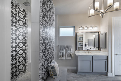 Inspiration for a large modern master bathroom in Atlanta with recessed-panel cabinets, grey cabinets, an open shower, black tile, gray tile, ceramic tile, grey walls, porcelain floors, an undermount sink, engineered quartz benchtops, grey floor, an open shower and white benchtops.